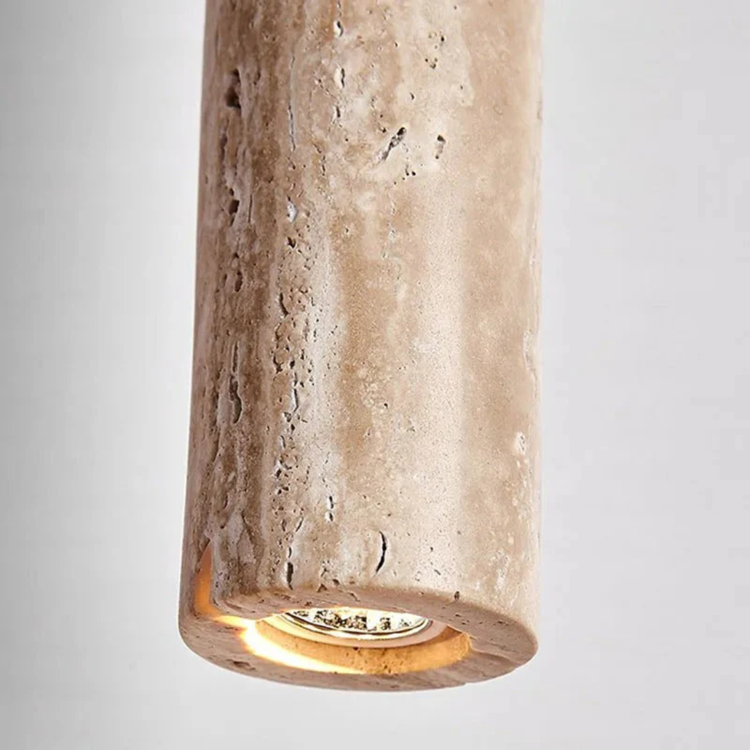 Gros plan sur la texture poreuse et naturelle de la pierre de travertin de la suspension Ligne de Pierre.