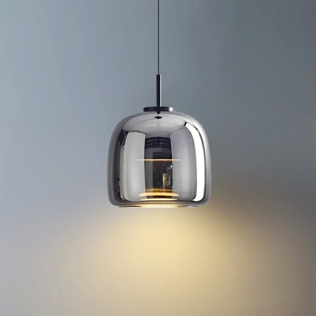 Suspension Éclat en verre fumé gris avec une forme arrondie élégante, idéale pour une ambiance feutrée.