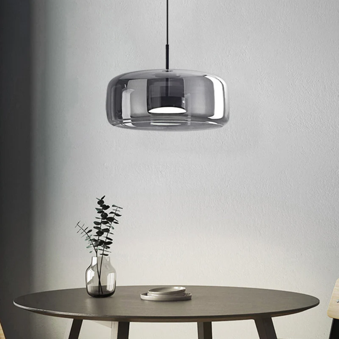 Mise en situation de la suspension Éclat en verre fumé au-dessus d'une table d'appoint dans un salon moderne.