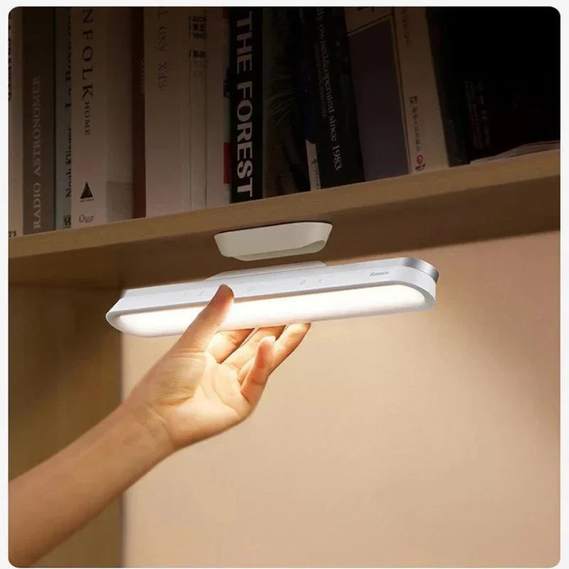Lampe Intuitive fixée sous une étagère de bibliothèque grâce à son support magnétique.