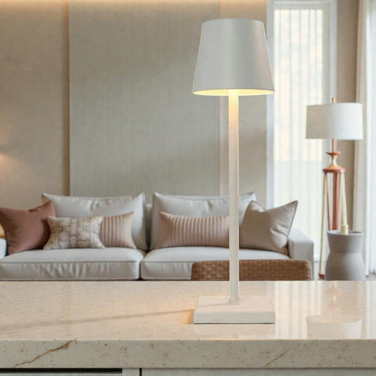 Élégante lampe de table LED sans fil Aura blanche installée dans un salon moderne et lumineux.