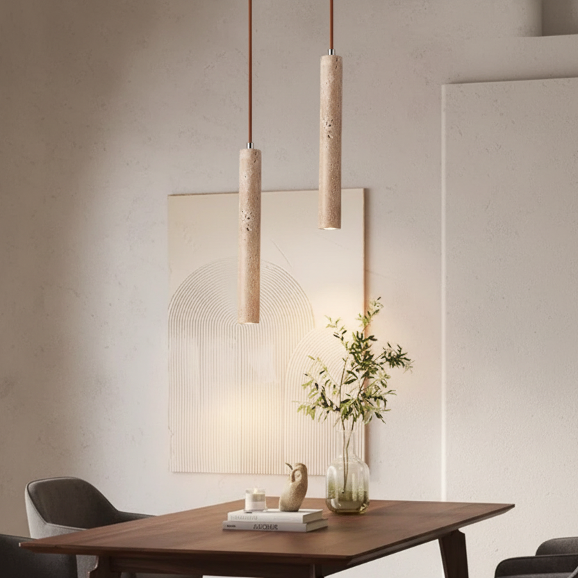 Ligne de Pierre, une suspension cylindrique minimaliste au-dessus d'une table de salle à manger.
