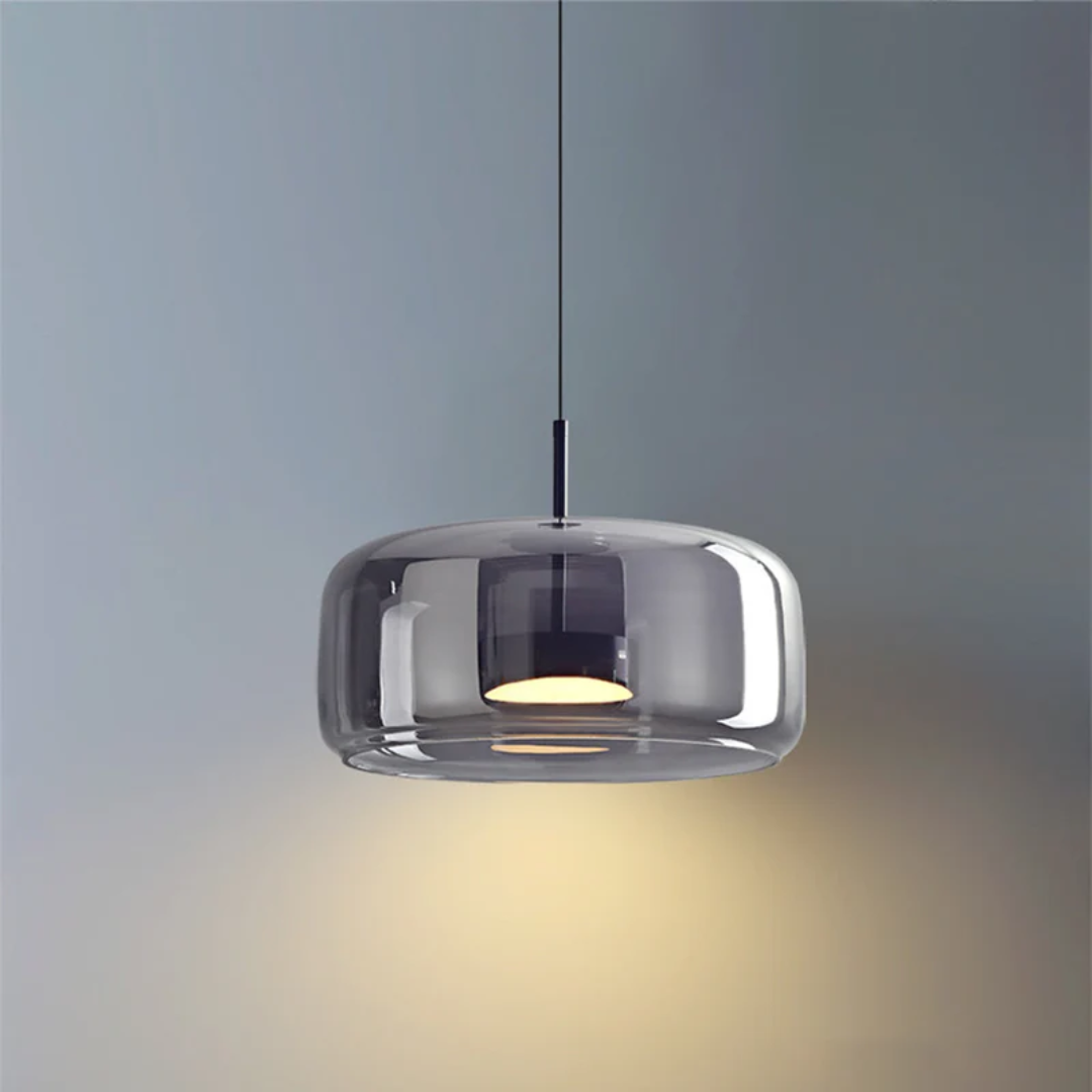 Luminaire suspendu Éclat avec abat-jour en verre fumé gris offrant un éclairage tamisé et moderne.