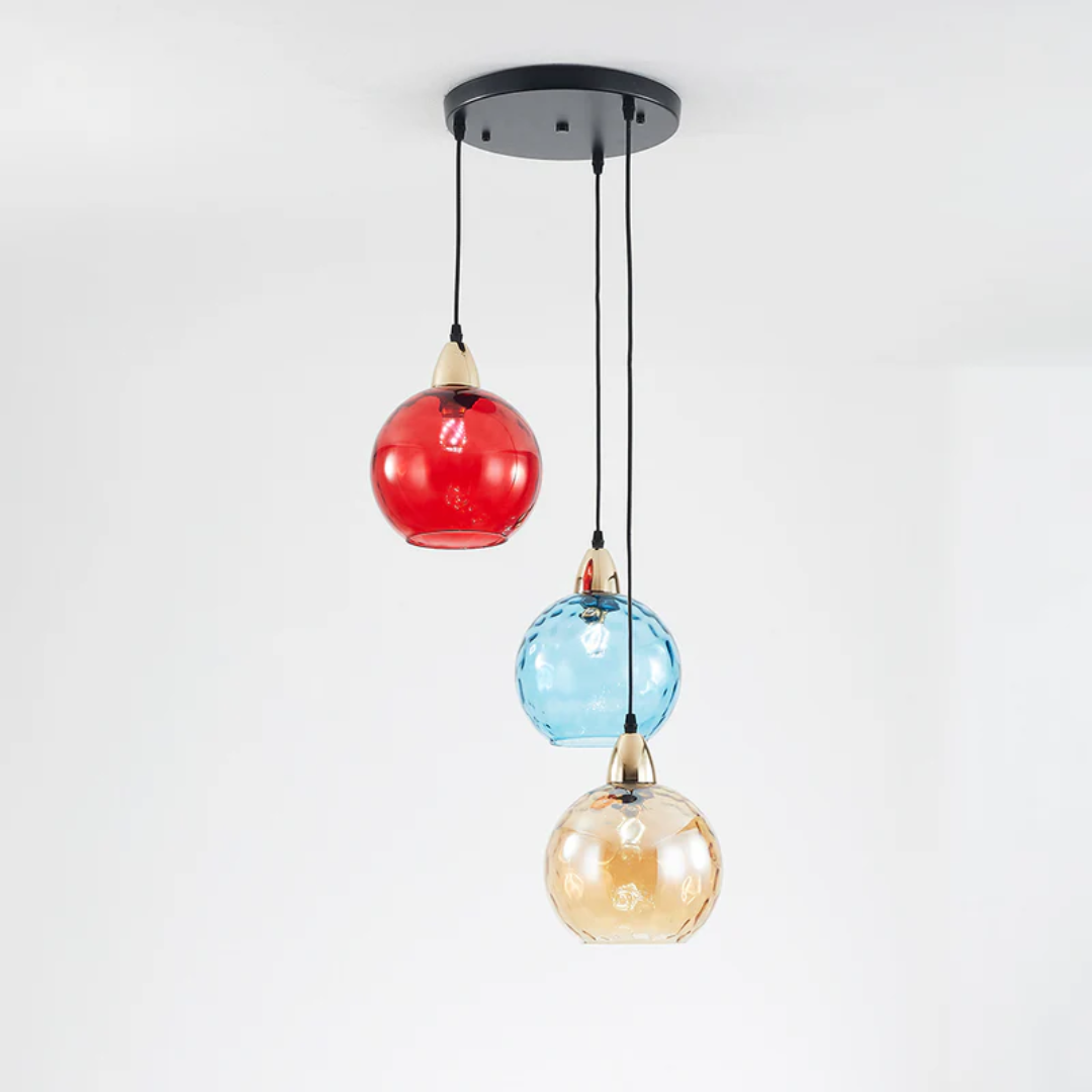 Lustre triple avec base ronde noire et globes en verre strié rouge, bleu et ambre.