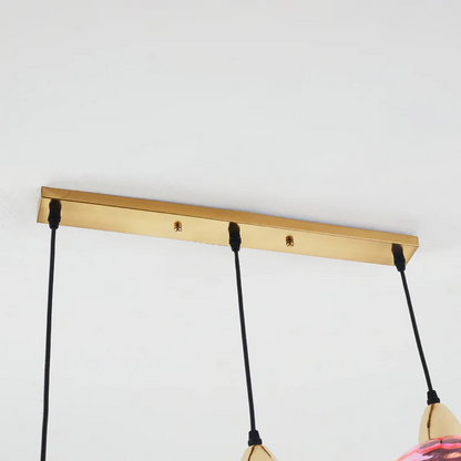 Détail de la barre de fixation horizontale dorée pour lustre triple avec câbles réglables.