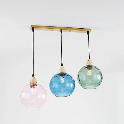 Lustre triple design avec globes en verre bleu océan, vert forêt et rose tendre.